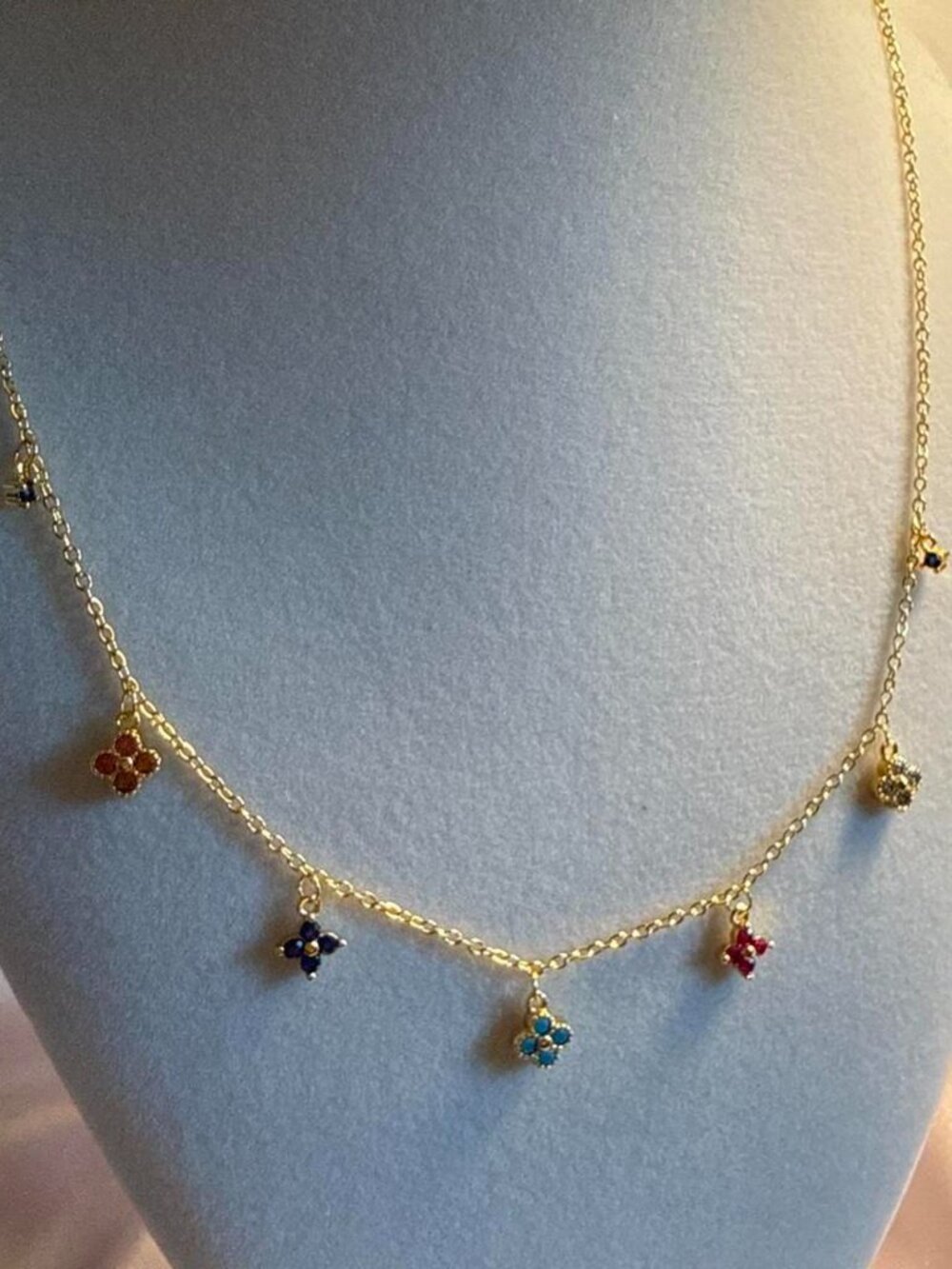 Gold necklace with small floral charms in various colors